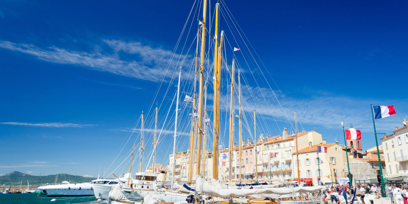 Vue sur les yachts élégants amarrés au port de Saint-Tropez en octobre, avec les collines en arrière-plan et une atmosphère calme et exclusive.