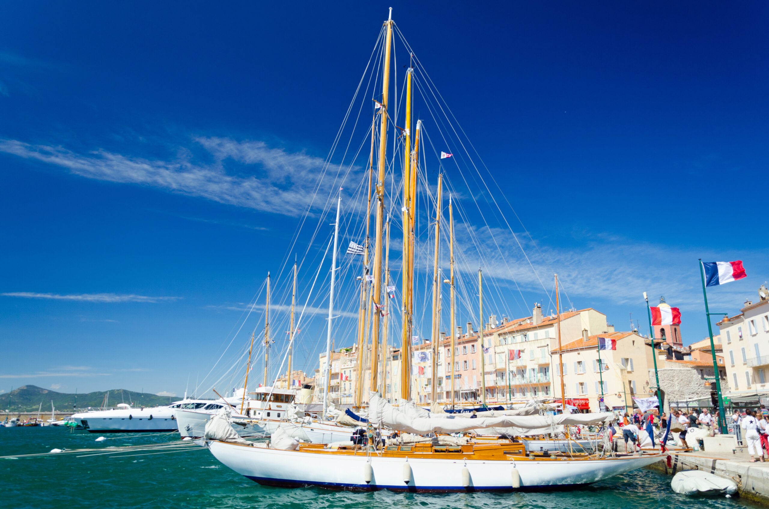 Vue sur les yachts élégants amarrés au port de Saint-Tropez en octobre, avec les collines en arrière-plan et une atmosphère calme et exclusive.